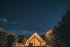 tente marron et blanche sous un ciel bleu pendant la nuit