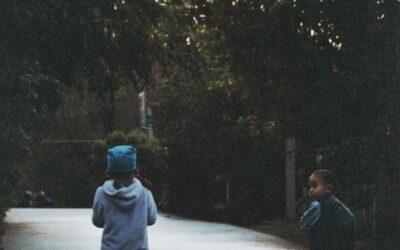 Deux enfants conduisant des scooters dans une rue calme
