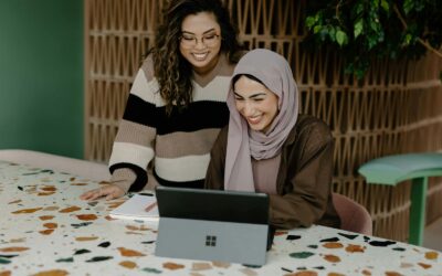 Deux femmes assises à une table avec un ordinateur portable