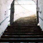 Escalier intérieur avec barrière métallique noire de sécurité, murs blancs