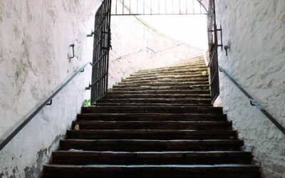 Escalier intérieur avec barrière métallique noire de sécurité, murs blancs