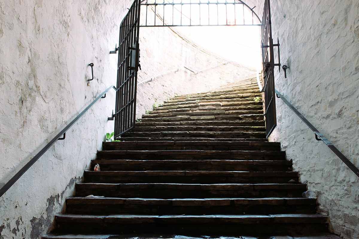 Escalier intérieur avec barrière métallique noire de sécurité, murs blancs