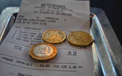 Un reçu, trois pièces et une assiette métallique sur plateau