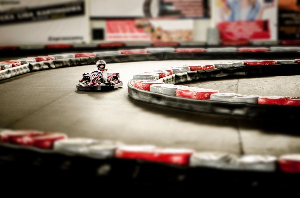 Un karting intérieur avec un conducteur pilotant un kart sur une courbe