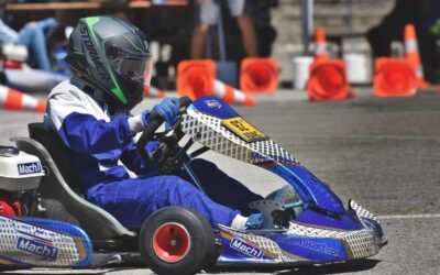 Un coureur en combinaison bleue pilote un kart bleu sur circuit