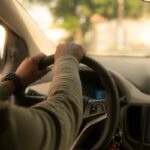 Un homme conduit une voiture, le volant en main