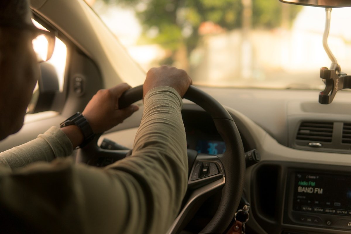 Un homme conduit une voiture, le volant en main